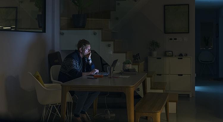 A man browsing in his laptop at night